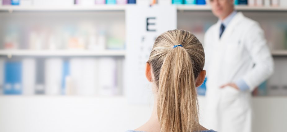 female patient sittting in doctor's office reading an eye chart