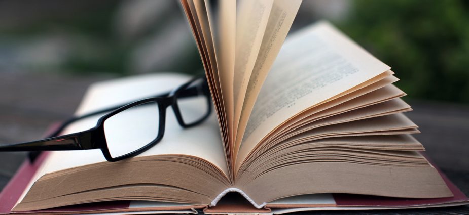 reading glasses resting on top of an open book