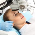 female eye surgery patient having her eye examined by her doctor