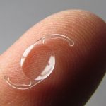 ultra close up of an intraocular lens (IOL) on a fingertip