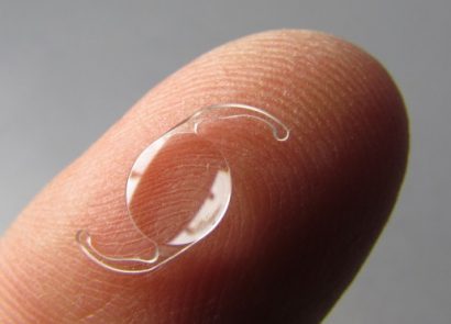 ultra close up of an intraocular lens (IOL) on a fingertip