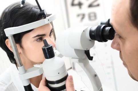 a young female patient at the optician having her vision tested