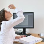 female office worker takes a break from her computer to apply eye drops