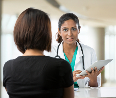 female doctor in a white lab coat speaking with a female patient about vision treatment