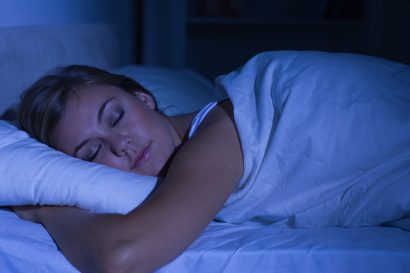 a young woman sleeping in her bed at night