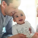 young parents laugh and play with their baby boy