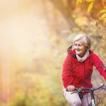 older woman riding her bike in the fall