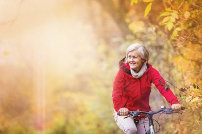 older woman riding her bike in the fall